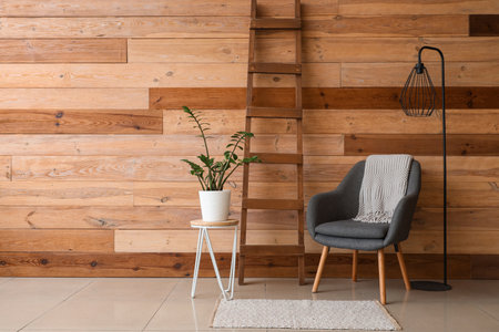 Interior of living room with wooden ladder, armchair and lampの写真素材