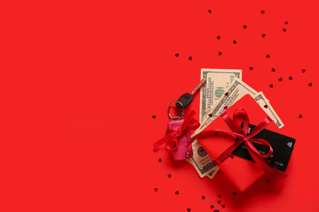 Gift box, credit card, keys of new car and money on red backgroundの写真素材