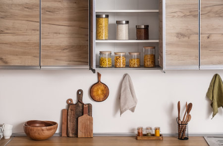 Glass jars with different products on shelves in kitchen