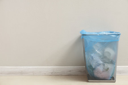 Full trash bin near white wallの写真素材