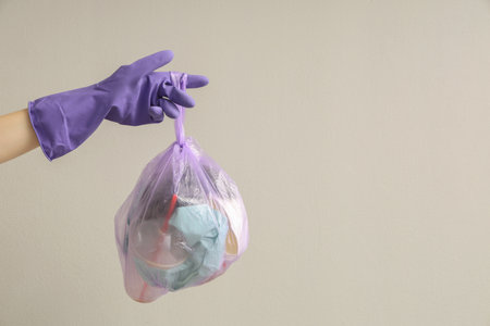 Woman with full garbage bag on white backgroundの写真素材