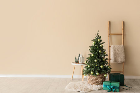 Small Christmas tree and gift boxes near white wallの写真素材