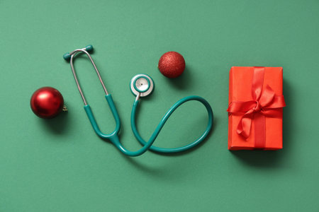Stethoscope with gift box and Christmas balls on green backgroundの写真素材