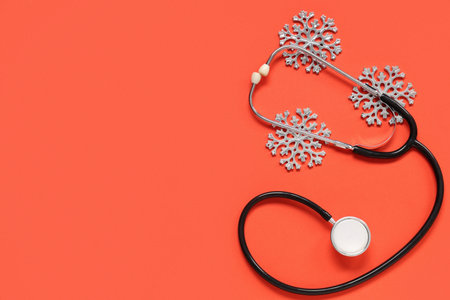 Stethoscope with decorative Christmas snowflakes on red backgroundの写真素材