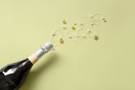 Bottle of champagne with Christmas decor on light green backgroundの写真素材