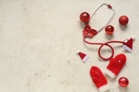 Stethoscope with Christmas balls and knitted mittens on light backgroundの写真素材