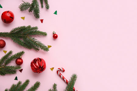 Composition with Christmas branches, balls and candy canes on pink background. Top viewの写真素材