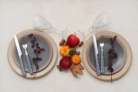 Beautiful table setting with fresh pumpkins, apples, acorns and rose hip berries on white background
