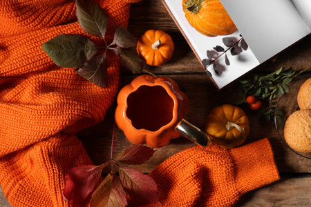 Autumn composition with cup of green tea, pumpkins and sweater on wooden background