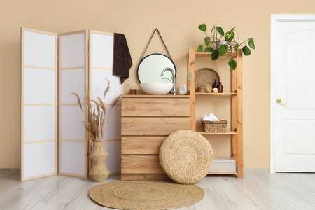 Interior of light bathroom with sink, chest of drawers and folding screenの写真素材