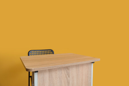 Modern school desk and chair in room near yellow wallの写真素材