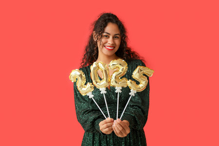 Happy African-American woman with figure 2025 made of balloons on red background. New Year...