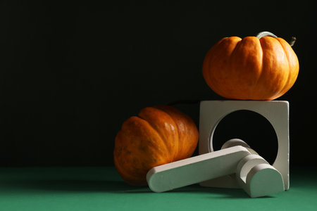 Decorative podiums with fresh pumpkins on green tableの写真素材