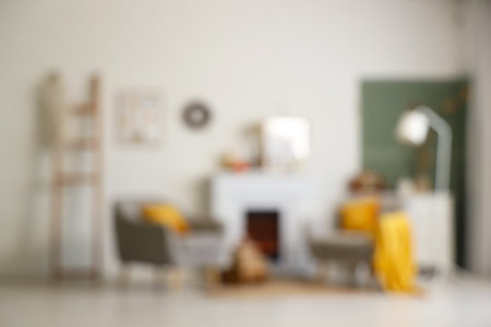 Armchairs, fireplace with autumn decor in interior of living room. Blurred viewの写真素材
