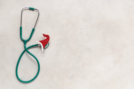 Stethoscope with decorative Christmas hat on light backgroundの写真素材