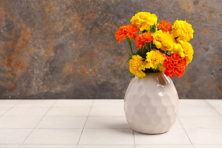 Vase with beautiful marigold flowers on light tile table. El Dia de Muertosの写真素材
