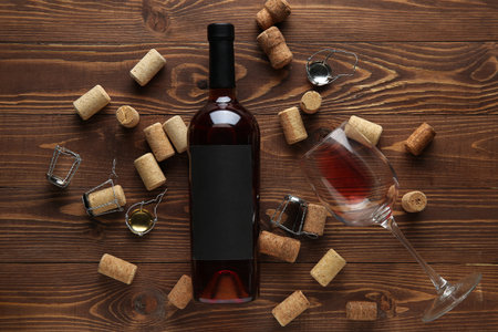 Bottle of red wine, glass and corks on wooden backgroundの写真素材