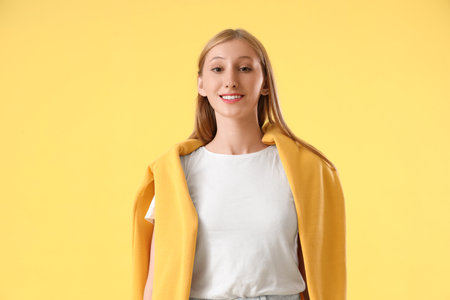 Young pretty woman on yellow backgroundの写真素材