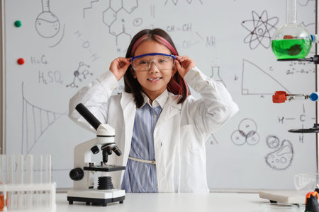 Cute little girl with scientific equipment in chemistry classroom