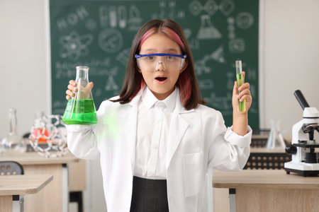 Cute little girl studying chemistry in science classroomの写真素材