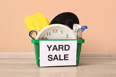 Basket of unwanted stuff for yard sale near beige wall