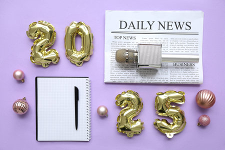 Figure 2025 with journalist's items and Christmas balls on lilac background