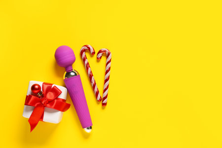 Vibrator, Christmas gift and decorations on yellow backgroundの写真素材