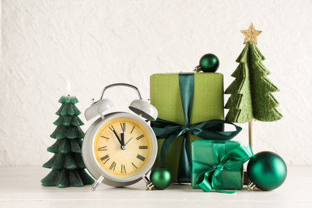 Alarm clock and Christmas decor on table against white background