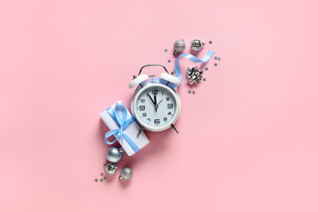 Alarm clock and Christmas decor on pink background. Top viewの写真素材
