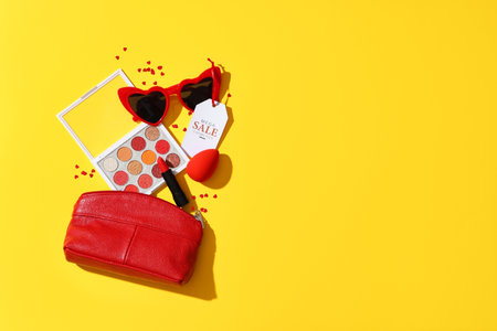 Composition with decorative cosmetics, accessories and sale tag on yellow backgroundの写真素材