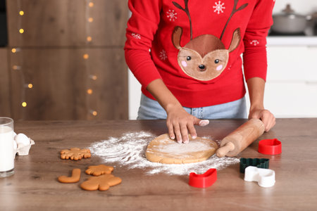 Young woman preparing dough for gingerbread cookies at table in kitchen on Christmas Eve, closeupの写真素材