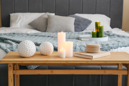 Burning candles in interior of modern bedroom