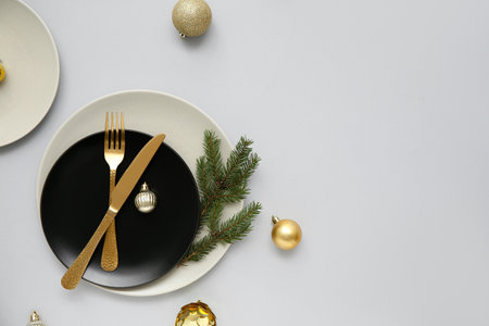 Beautiful table setting with Christmas balls and fir branch on gray backgroundの写真素材