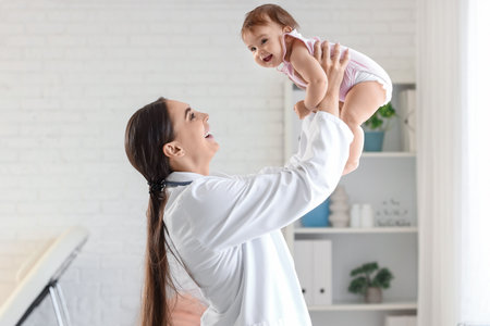 Female pediatrician holding little baby in clinicの写真素材