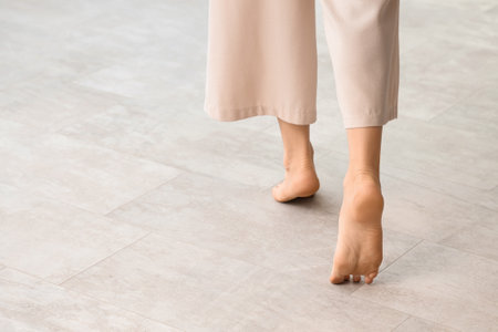 Young woman with flat feet on floor at home, back viewの写真素材