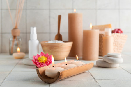 Burning candles, flower and spa supplies on light backgroundの写真素材