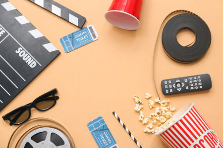 Frame made of movie clapper with cinema tickets, glasses, popcorn and film reels on beige backgroundの写真素材