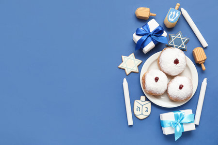 Composition for Hanukkah celebration with donuts, dreidels and gift boxes on blue backgroundの写真素材