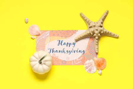 Card for Thanksgiving Day with pumpkin, starfish and seashells on yellow backgroundの写真素材