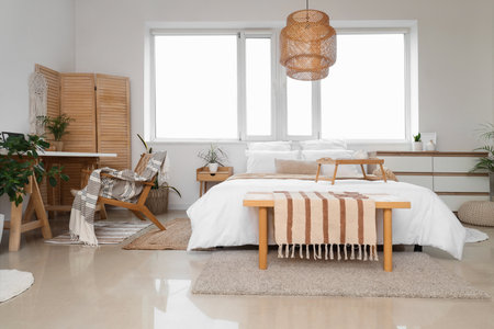 Stylish interior of light bedroom with workplaceの写真素材