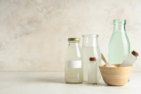Different bottles of rice water and grains on light backgroundの写真素材