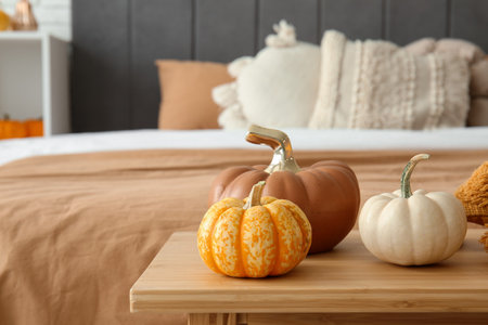 Ceramic and real pumpkins on bench in bedroomの写真素材