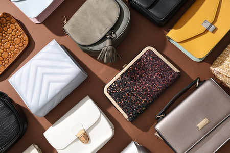 Different stylish bags on brown background