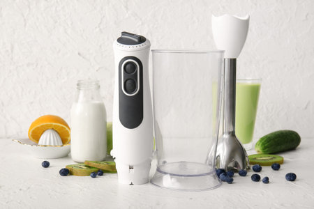 Modern blender with bottle of milk, fruits and berries on white background
