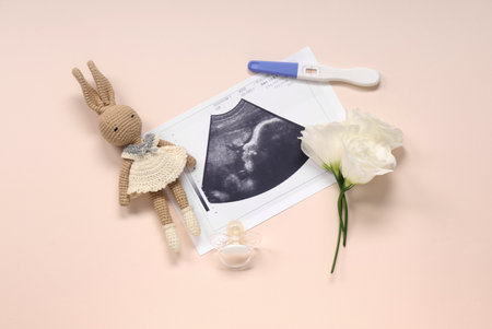 Composition with pregnancy test, sonogram images, toy rabbit and nipple on pink backgroundの写真素材