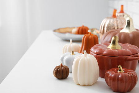 Candles in shape of pumpkin on chest of drawers near white brick wall. Closeupの写真素材