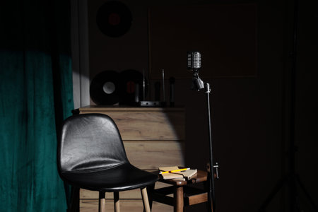 View of standup scene with stool, table and microphone in dark room