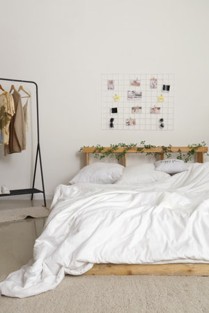 Interior of stylish bedroom with cozy bed and mood board hanging on wallの写真素材