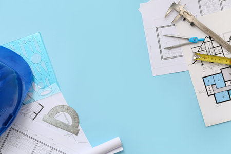 Frame made of architect's supplies with house plans on blue background