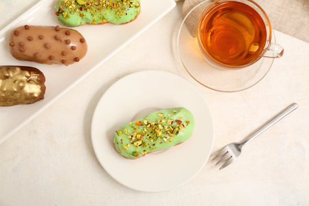 Sweet eclairs and tea on light backgroundの写真素材
